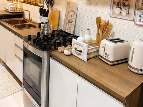 Mueble bajo mesada blanco línea Glamy de Madesa con cubierta amaderada, anafe y horno en una cocina lineal.