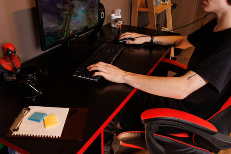 Adolescente usando la Mesa Gamer Madesa negra con monitor, teclado y mouse, ideal entre los muebles para chicos